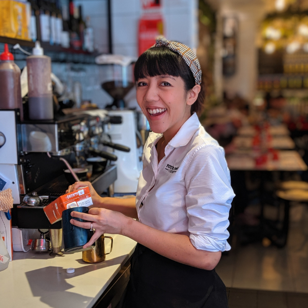 A staff member making coffee